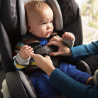 Disney Baby EverSlim 4-in-1 Convertible Car Seat - Vintage Disney - baby being buckled into seat