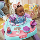 Baby sitting in a colorful activity center with toys in a home setting