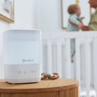 Comforting Cool Mist Top-Fill Humidifier - humidifier on nightstand as mother picks baby up from crib in background