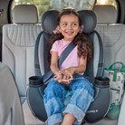 Child in a car seat with a safety 1st label, sitting in a car.