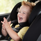 Child laughing in a car seat with a blurred background