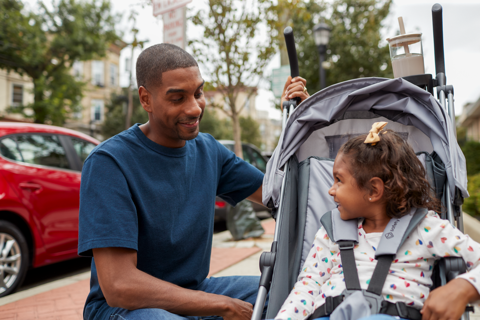 father smiling at daughter in stroller