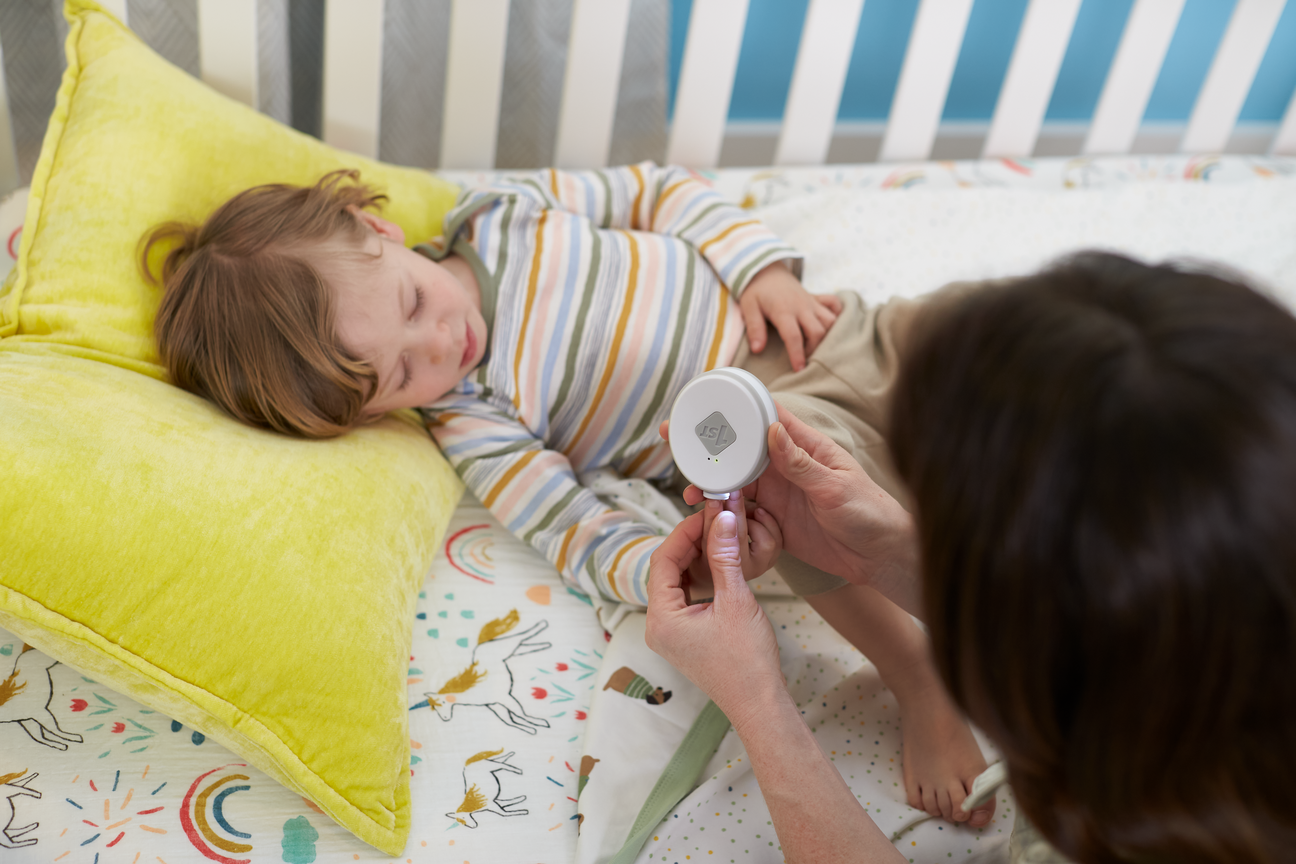 baby getting nails trimmed by mother in crib