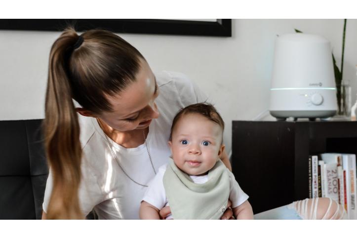 mother holding baby and smiling