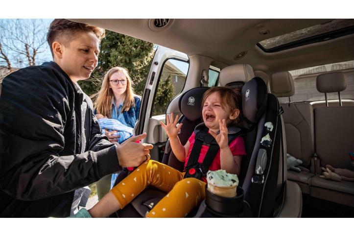 child having tantrum in car seat