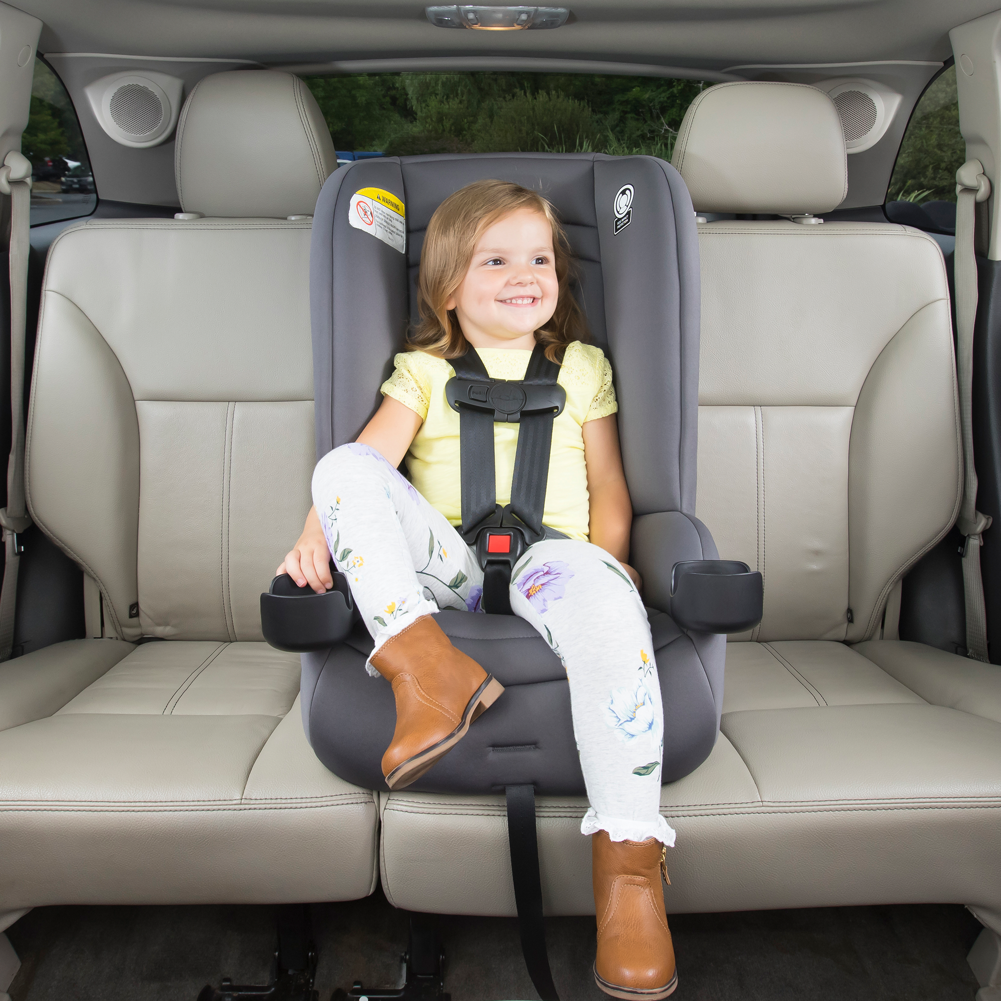 girl smiling while sitting in middle row car seat