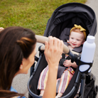 onBoard™ Slide 6-in-1 Travel System with SafetySlide™ Base - mother strolling toddler in rear-facing mode