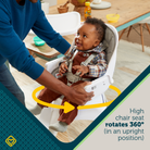 Child in a high chair with a 360-degree rotation feature, being adjusted by an adult.