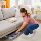 Rest-and-Romp Play Yard - mother placing folded up play yard under sofa