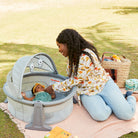 Sleepy Traveler™ Bassinet - mother doting on baby in bassinet in a park