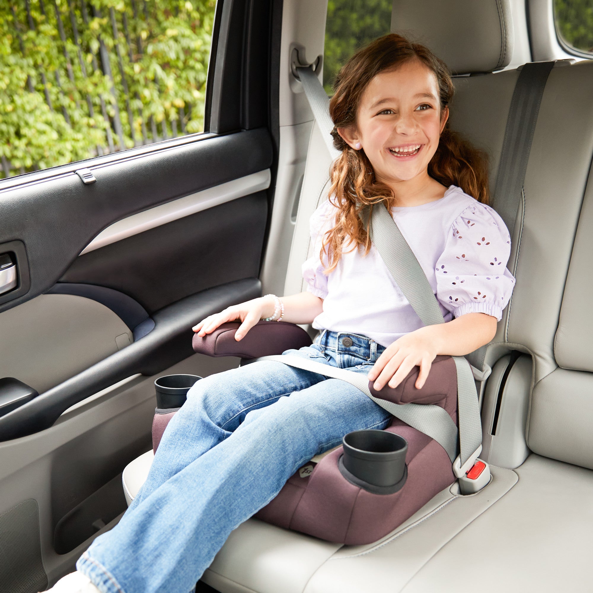 Boost-and-Go All-in-One Harness Booster Car Seat - Dunes Edge - smiling girl strapped into backless booster