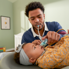 Man administering a nasal spray to a baby in a nursery setting